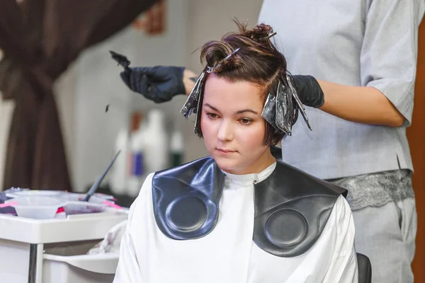 Coiffeur coloriage client femme cheveux dans salon de coiffure beauté studio, en utilisant brosse et feuille, teinture professionnelle et concept de traitement — Photo