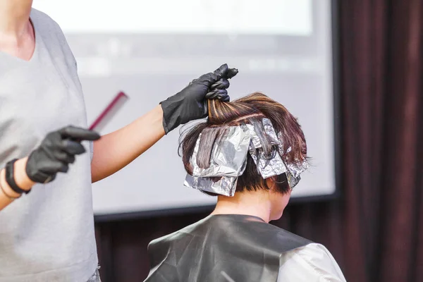 Coiffeur coloriage client femme cheveux dans salon de coiffure beauté studio, en utilisant brosse et feuille, teinture professionnelle et concept de traitement — Photo