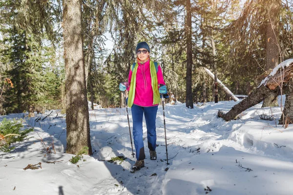 Mulher caminhante viajando com mochila e equipamento de trekking na floresta trilha de neve em montanhas, atividade de inverno e conceito de recreação — Fotografia de Stock