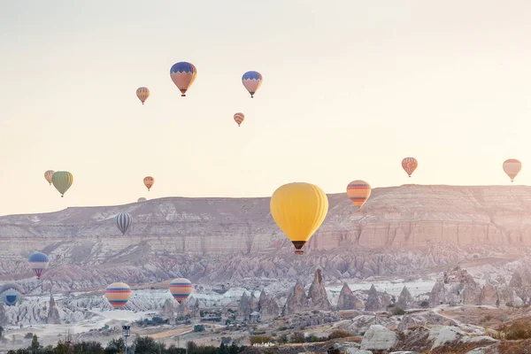 Vele hete lucht ballonnen vliegen over rotsachtige landschap in Goreme stad in Cappadocië, Turkije — Stockfoto