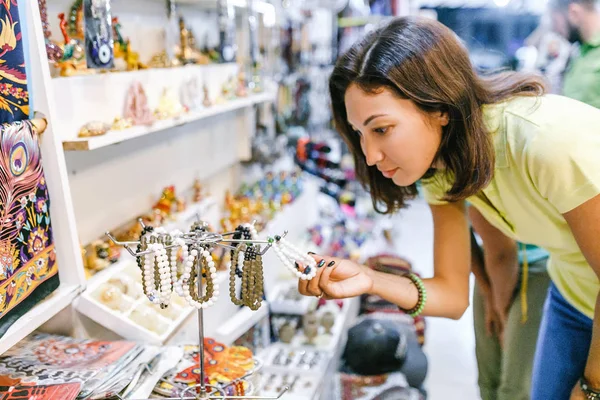 Женщина выбирает браслет из бусин в магазине — стоковое фото
