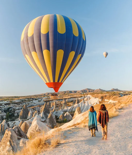 Una chica turística en la cima de una montaña disfrutando de una maravillosa vista del amanecer y globos en Capadocia. Concepto de viaje feliz en Turquía —  Fotos de Stock