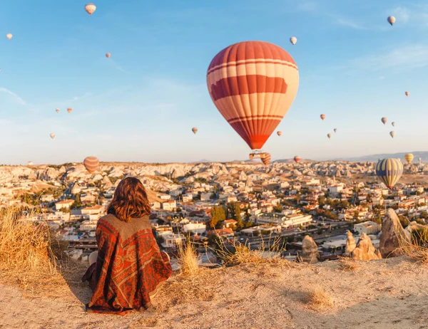 Una chica turística en la cima de una montaña disfrutando de una maravillosa vista del amanecer y globos en Capadocia. Concepto de viaje feliz en Turquía —  Fotos de Stock