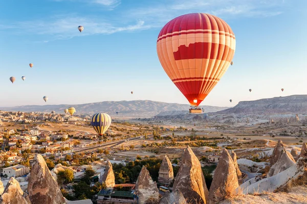 Vele hete lucht ballonnen vliegen over rotsachtige landschap in Goreme stad in Cappadocië, Turkije — Stockfoto
