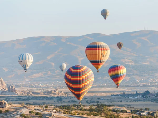 Goreme, Cappadocië, Turkije - 24 September 2017: hete lucht ballonnen vliegen boven fantastische schilderachtige landschap van Cappadocië — Stockfoto