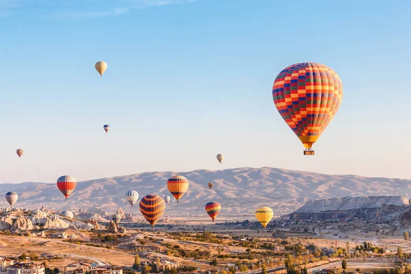 Muchos globos aerostáticos volando sobre el paisaje rocoso en la ciudad de Goreme en Capadocia, Turquía —  Fotos de Stock