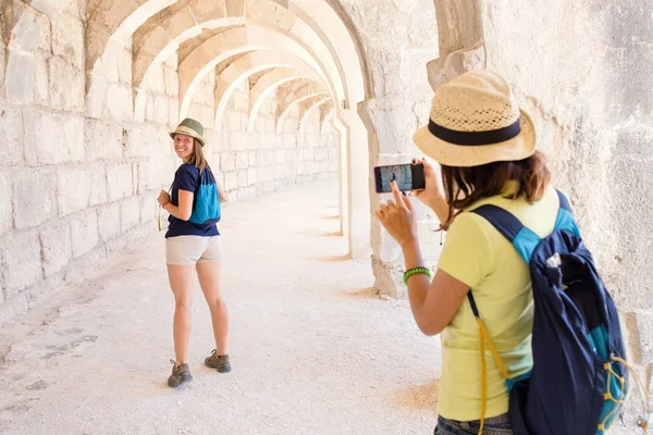 Rückansicht einer jungen Touristin mit Smartphone-Kamera — Stockfoto