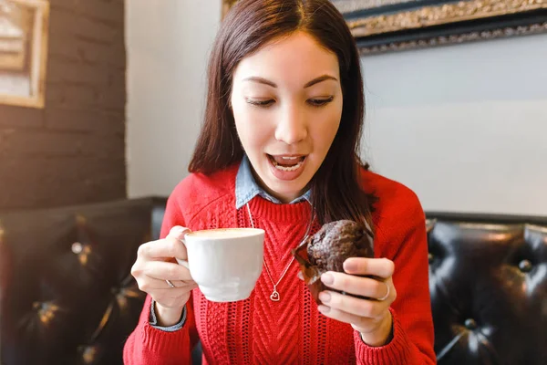 Молода жінка п'є каву та їсть смачний кекс у ретро-кафе, сніданок та концепцію хорошого ранку — стокове фото