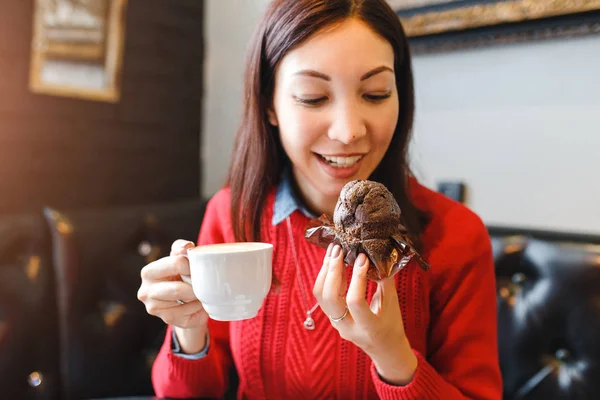 Mujer joven bebiendo café y comiendo un delicioso pastel de magdalenas en la cafetería retro, desayuno y buen concepto de la mañana — Foto de Stock