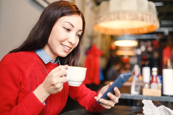 Крупный план портрета красивой молодой женщины с помощью мобильного телефона в кофейне — стоковое фото