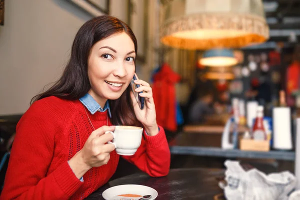 Εσωτερικη πορτρέτο του όμορφη νεαρή γυναίκα με το κινητό της τηλέφωνο στο καφενείο — Φωτογραφία Αρχείου