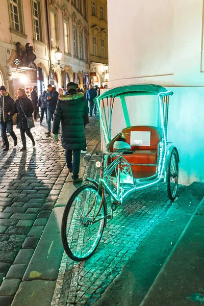 02 DICIEMBRE 2017, PRAGA, REPÚBLICA CHECA: rickshaw bicicleta con luces en una calle de la ciudad ocupada esperando a los clientes — Foto de Stock