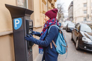 Kadın bir Parkmetre veya arka plan, yolda araba ile bilet ödeme istasyonu