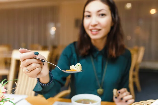 Portrét mladé ženy jíst polévku v restauraci — Stock fotografie