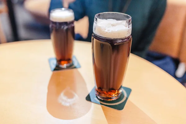 Dos vasos de cerveza oscura en la mesa en el bar — Foto de Stock