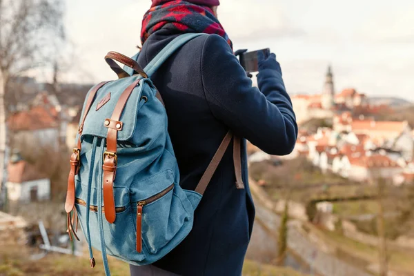 Mujer turista en un abrigo con una mochila viaja por las viejas calles de la ciudad de Cesky Krumlov, Europa concepto de vacaciones — Foto de Stock