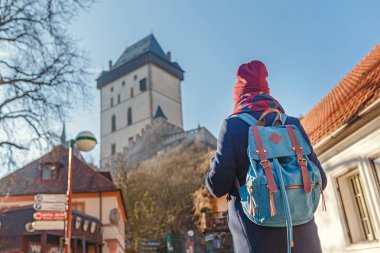 07 Aralık 2017, Karlstejn, Çek Cumhuriyeti: kadın Gezgin ile kış Ortaçağ Gotik castle Karlstejn, Çek Reoublic yakınındaki harita bakarak sırt çantası