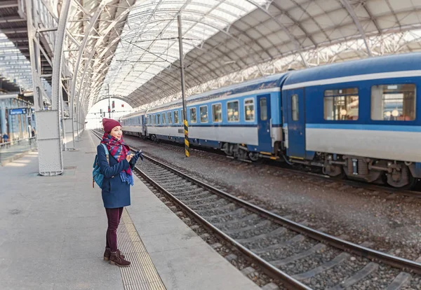 Kvinna turist väntar på ett tåg en postera på plattformen — Stockfoto