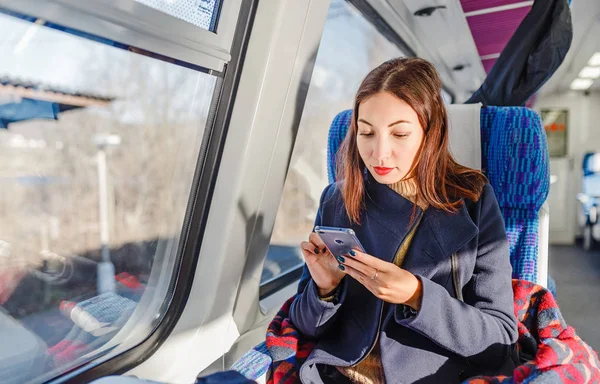 Traveler girl use mobile phone on the train, travel application concept — Stock Photo, Image