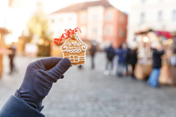 Mão com casa de gengibre gostoso tradicional no fundo da rua Chesky Krumlov decorado para o Natal — Fotografia de Stock