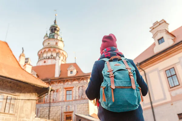 Kvinna turist i en kappa med en ryggsäck resor på de gamla gatorna i Cesky Krumlov city, Europa semester koncept — Stockfoto