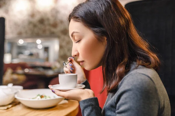 Молода східна жінка п'є міцну каву аромату в кафе — стокове фото