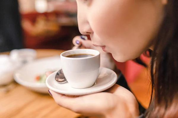 Молодая восточная женщина пьет крепкий ароматный кофе в кафе — стоковое фото