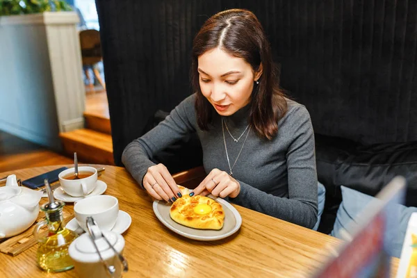 Žena jíst tradiční chačapury gruzínskou restaurací, místní kuchyni a výborné jídlo cestování koncepce — Stock fotografie