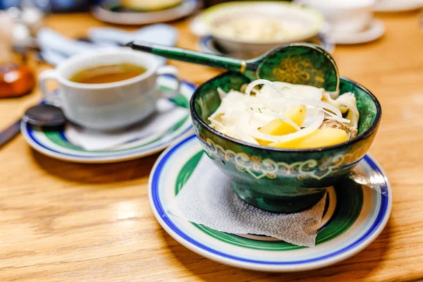 Elesh is a traditional dish in the Central Asian cuisine beef soup with noodles and vegetables in a wooden plate decorated with authentic national patterns — Stock Photo, Image