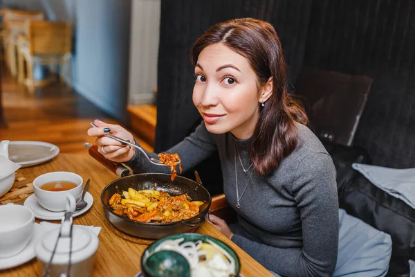 Азіатські жінки, що вживання в їжу м'яса від сковороду в ресторані — стокове фото