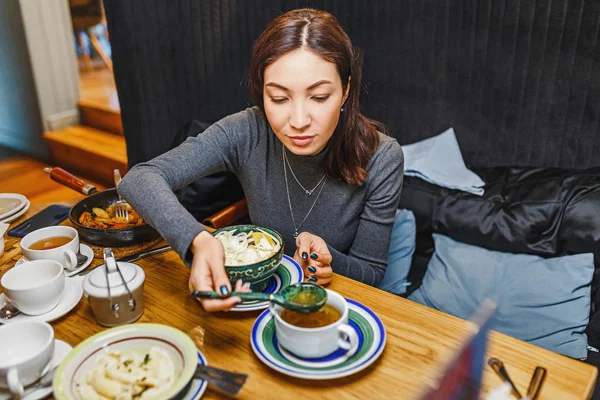 Žena jíst různé pokrmy v restauraci — Stock fotografie