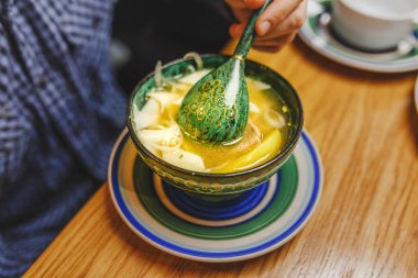 Elesh Orta Asya Mutfağı işkembe çorbası erişte ile geleneksel bir tabak ve otantik Ulusal desenlerle süslenmiş bir ahşap tabak sebze olduğunu