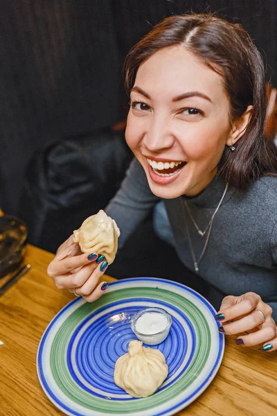 Веселий жінка їсть грузинський ресторан національної снек Хінкалі, що є родич кнедлики і raviolli — стокове фото