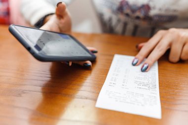 22 Nisan 2018, Ufa, Rusya Federasyonu: kadın bir cep telefonu hesap makinesi kullanarak fatura kontrol