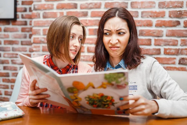 Duas meninas amigas em um café lendo o menu com emoções engraçadas — Fotografia de Stock