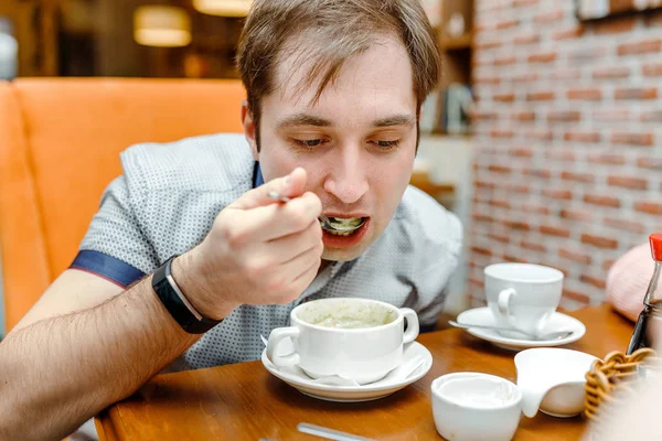 Portrét pohledný muž v kavárně jíst špenát Vegetariánská Polévky — Stock fotografie