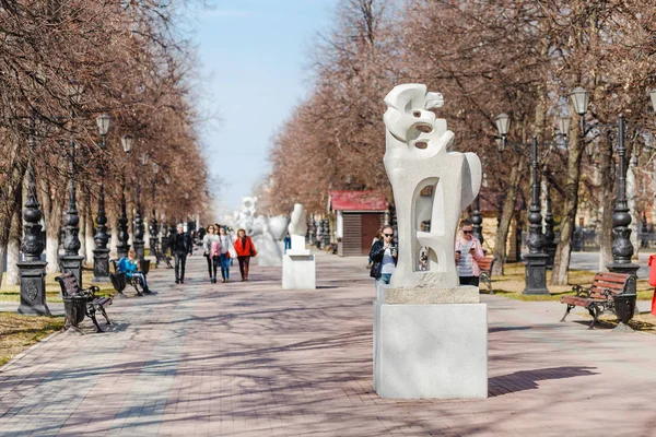 28 April 2018, Ufa, Rusland: inwoners van de stad van Oefa lopen langs een voetgangersstraat in het historische centrum van de stad met moderne kunst stenen sculpturen — Stockfoto