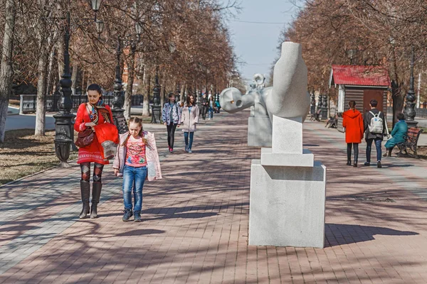 28 April 2018, Ufa, Rusland: inwoners van de stad van Oefa lopen langs een voetgangersstraat in het historische centrum van de stad met moderne kunst stenen sculpturen — Stockfoto