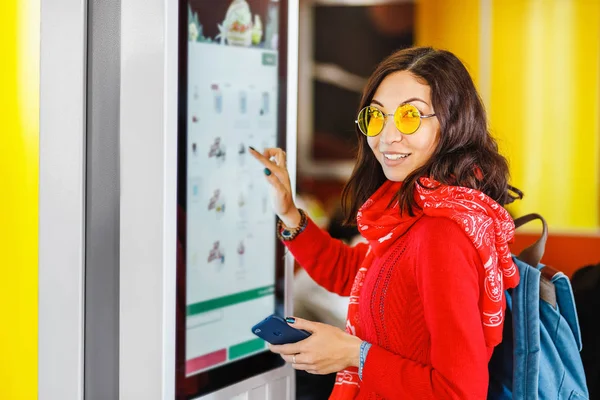 Hipster mujer asiática ordena comida en la pantalla táctil máquina de autoservicio por el menú electrónico en el restaurante de comida rápida — Foto de Stock