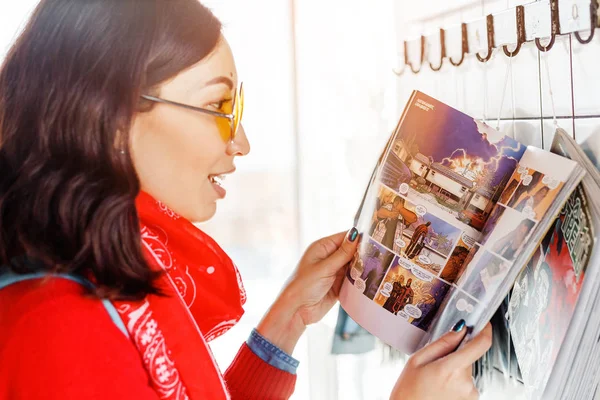 28 April 2018, Ufa, Ryssland: asiatisk kvinna läsa serier i en butik — Stockfoto
