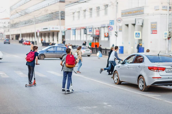 28 April 2018, Ufa, Ryssland: grupp kids på skoter korsa vägen på fel ställe, begreppet trafik regler för barn och farorna med trafikolyckor — Stockfoto