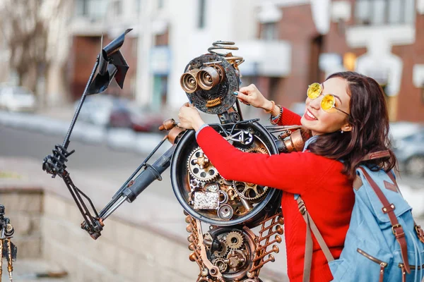 28 ABRIL 2018, UFA, RÚSSIA: Mulher tocando estátua robô criado a partir de lixo e resíduos de metal na rua da cidade de Ufa — Fotografia de Stock