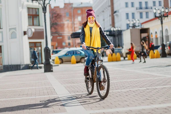 Хипстерская девушка катается на велосипеде по городской улице — стоковое фото