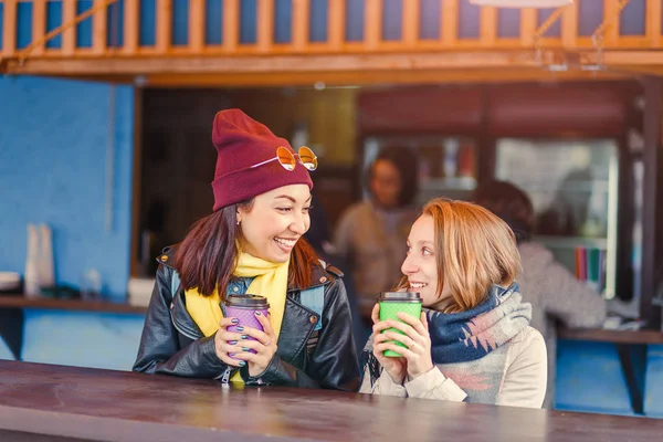 Koncept komunikace a přátelství - usmívající se dívky pití kávy ve venkovní kavárně a usmívá se — Stock fotografie