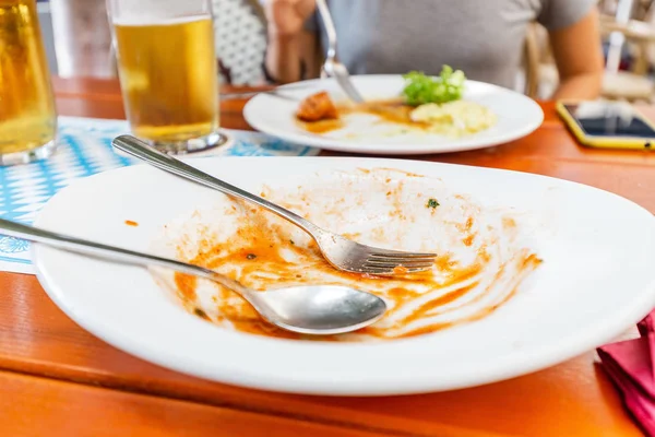 Грязная посуда на столе в ресторане. Концепция обжорства, голода и нездорового питания — стоковое фото