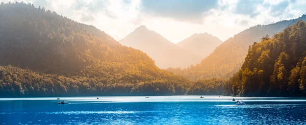 관광객들 이 보트를 타고 편안하게 쉬고 있는 호수 연석의 전경. 호엔 슈완 나우 마을 과 노이 슈반 슈타인 성의 관광 — 스톡 사진