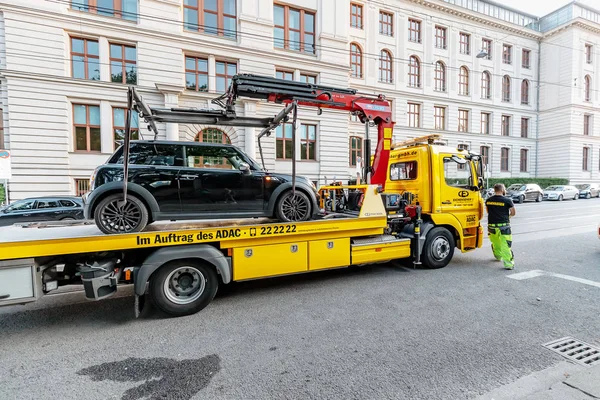 08 августа 2019, Мюнхен, Германия: эвакуатор увозит автомобиль за неправильную парковку на городской улице — стоковое фото