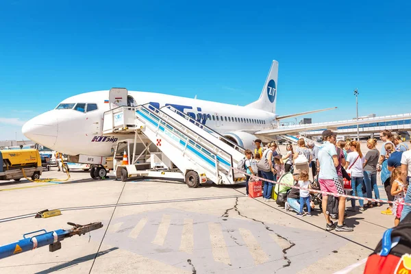 09 Agosto 2019, Viena, Austria: La gente permanece en línea abordando un avión de las aerolíneas UTair — Foto de Stock