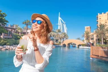 Dubai tatil köyünde mojito içen mutlu kız. Birleşik Arap Emirlikleri konseptinde seyahat ve tatil