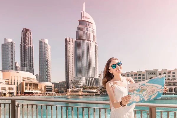 Happy tourist girl looking for attractions in financial business center in Asian city with skyscrapers — Stock Photo, Image